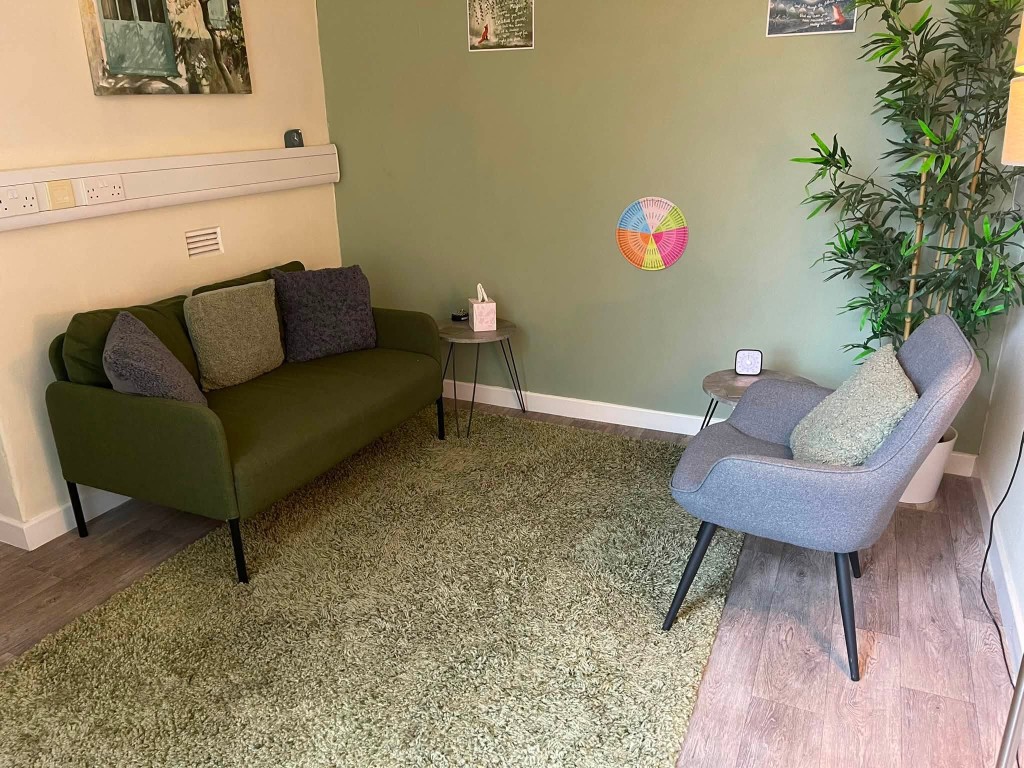 A counselling room in Keighley with a green sofa, armchair and soft natural light